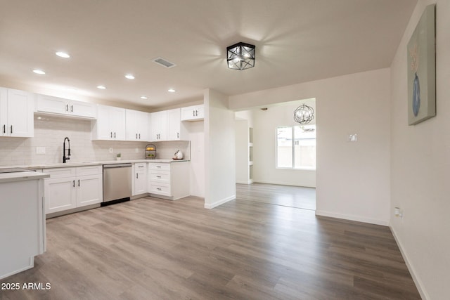 3620 E Ludlow Dr, Phoenix, AZ 85032 - kitchen featuring stainless steel dishwasher, wood finished floors, a sink, decorative backsplash, and baseboards