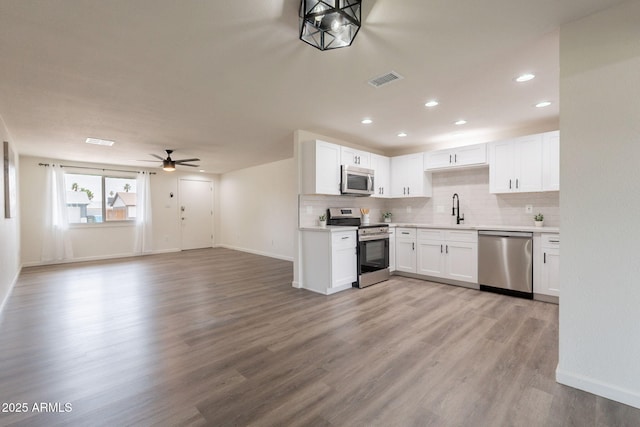 3620 E Ludlow Dr, Phoenix, AZ 85032 - kitchen featuring appliances with stainless steel finishes, baseboards, light countertops, backsplash, and white cabinetry