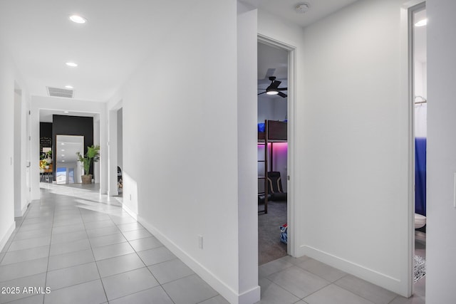 corridor featuring light tile patterned floors, recessed lighting, visible vents, and baseboards