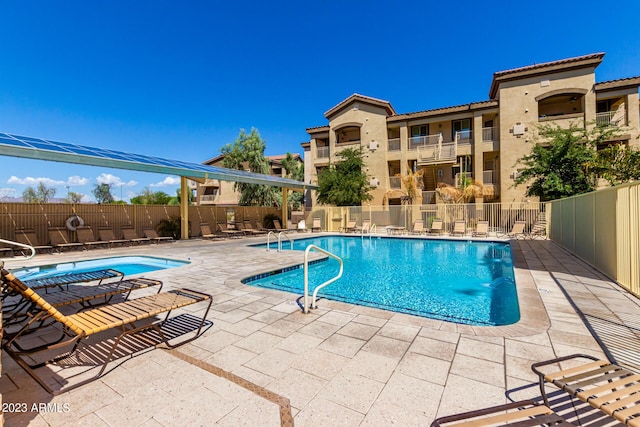 pool with a patio and fence