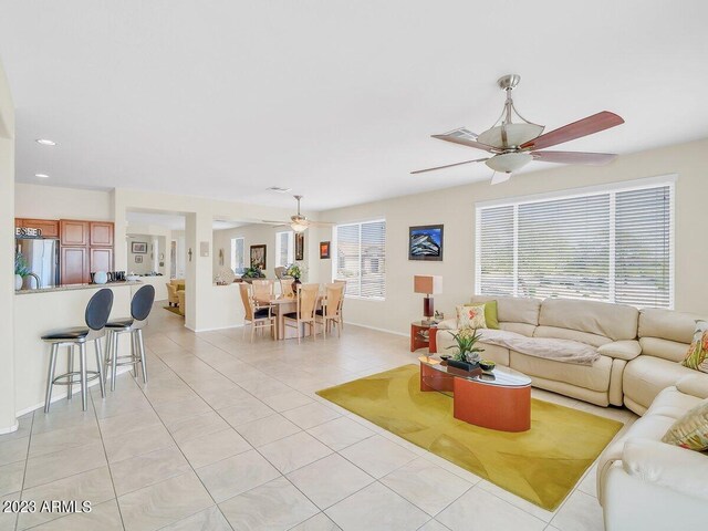 living room with ceiling fan, light tile patterned flooring, and a healthy amount of sunlight