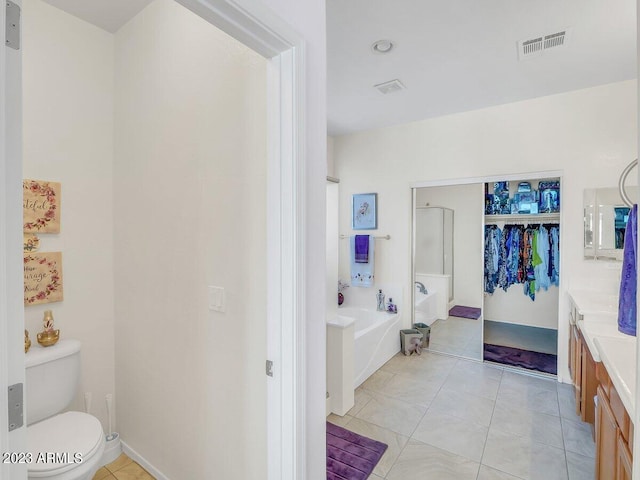 bathroom featuring vanity, toilet, tile patterned flooring, and a bathtub