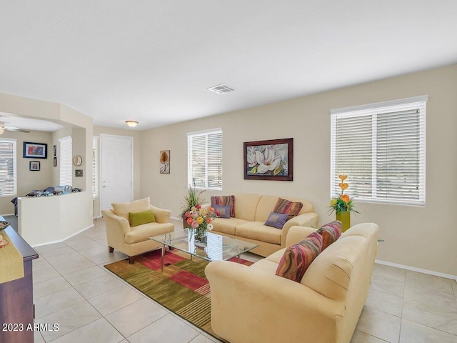 living room featuring ceiling fan, light tile patterned floors, and plenty of natural light