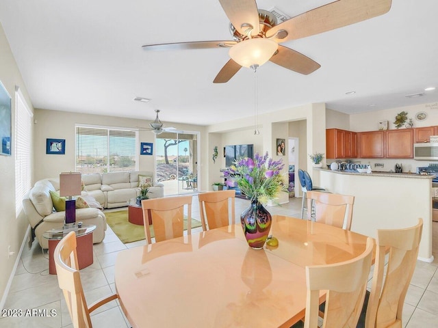 dining area with light tile patterned floors and ceiling fan