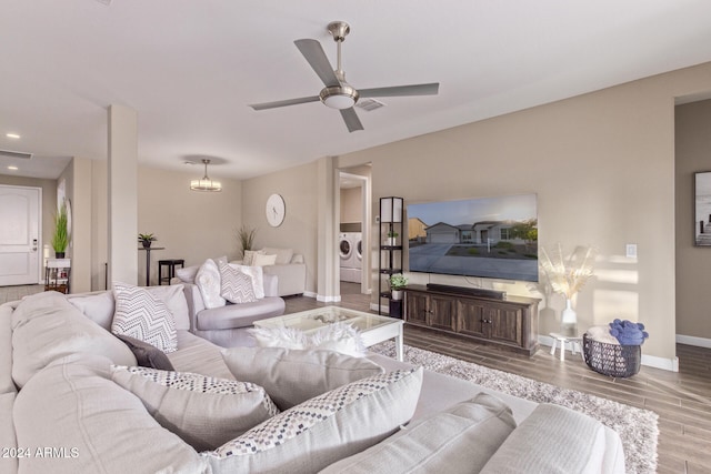 living room with hardwood / wood-style floors, ceiling fan, and washer / dryer