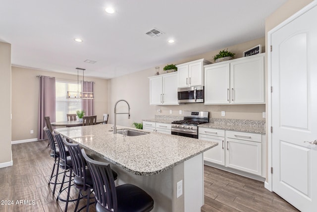 kitchen featuring stainless steel appliances, white cabinetry, dark hardwood / wood-style floors, and sink