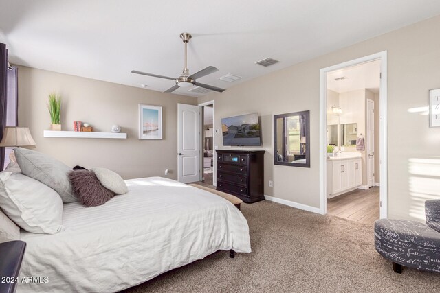 bedroom with ensuite bathroom, ceiling fan, and light wood-type flooring