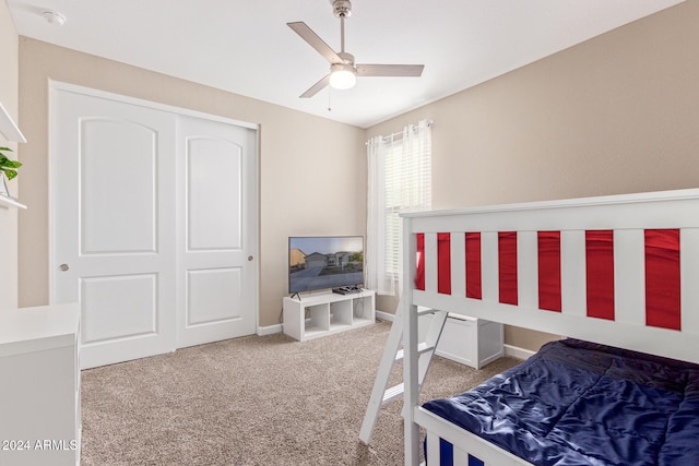 carpeted bedroom featuring ceiling fan and a closet