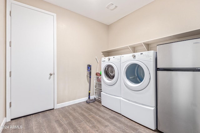 laundry area featuring independent washer and dryer and light wood-type flooring