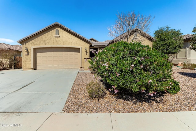 view of front of home featuring a tiled roof, stucco siding, driveway, and a garage