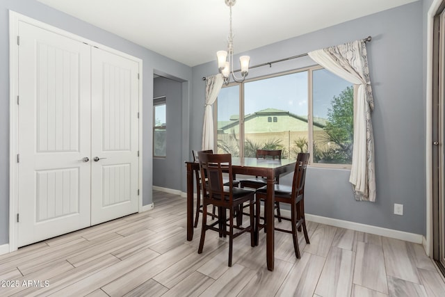 dining room with wood finish floors, baseboards, and a chandelier