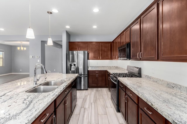 kitchen featuring light stone counters, recessed lighting, a sink, black appliances, and pendant lighting