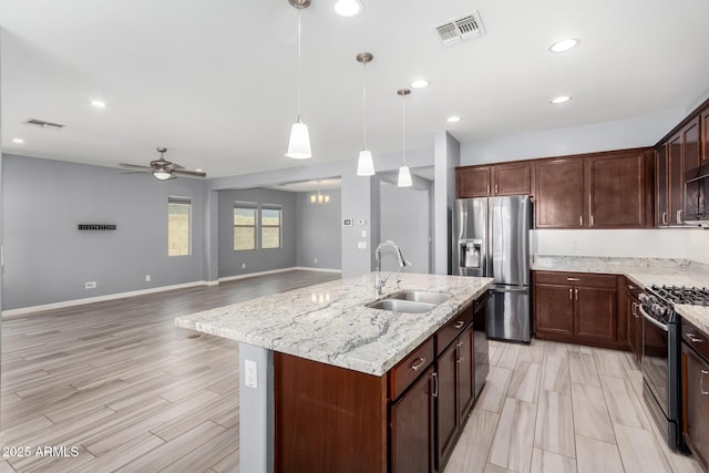 kitchen with visible vents, light stone countertops, black appliances, a ceiling fan, and a sink