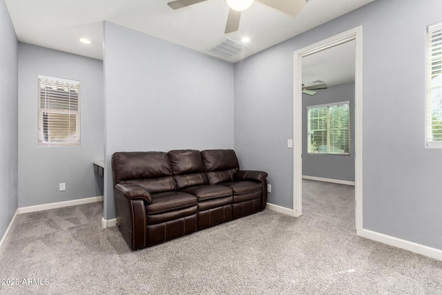 living room with carpet flooring, a ceiling fan, visible vents, and baseboards