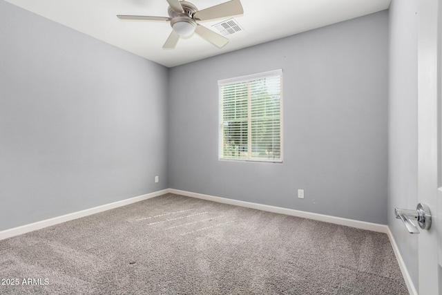 carpeted spare room with visible vents, baseboards, and a ceiling fan