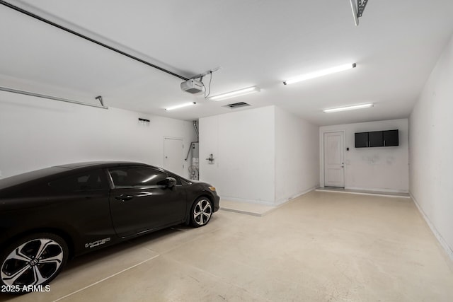 garage featuring baseboards, secured water heater, and a garage door opener