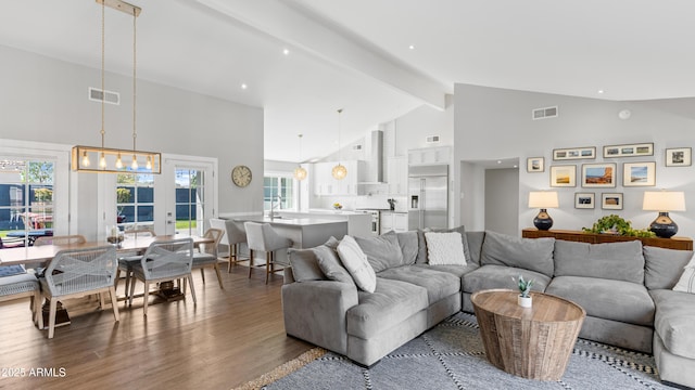 living room with beamed ceiling, wood finished floors, visible vents, and high vaulted ceiling