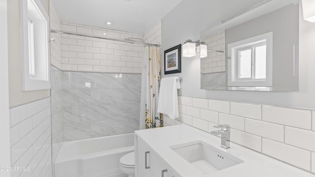 bathroom featuring tile walls, toilet, vanity, and shower / tub combo