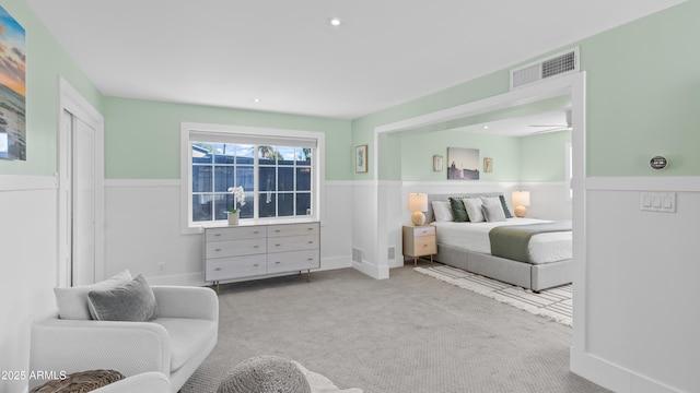 carpeted bedroom featuring recessed lighting, visible vents, and wainscoting