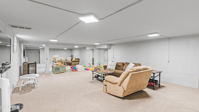 living area featuring visible vents, carpet floors, and brick wall