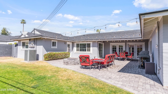 back of property featuring fence, central air condition unit, an outdoor fire pit, a lawn, and french doors