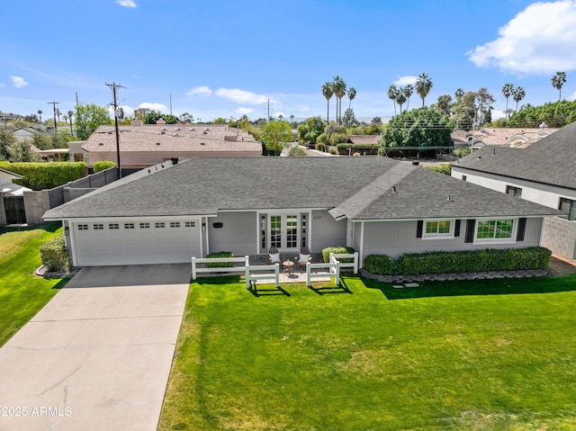 ranch-style home with a garage, concrete driveway, a shingled roof, and a front yard