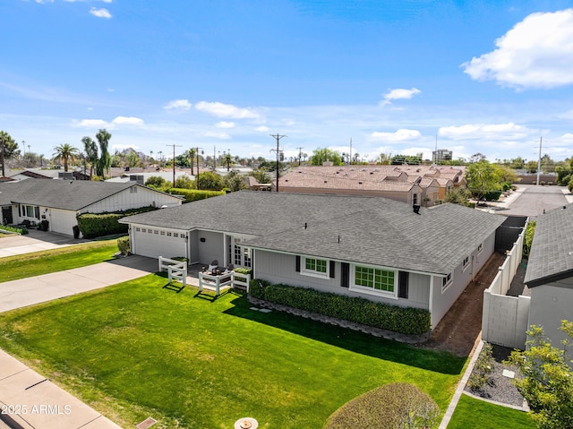 ranch-style home with a front yard, a residential view, driveway, and a shingled roof