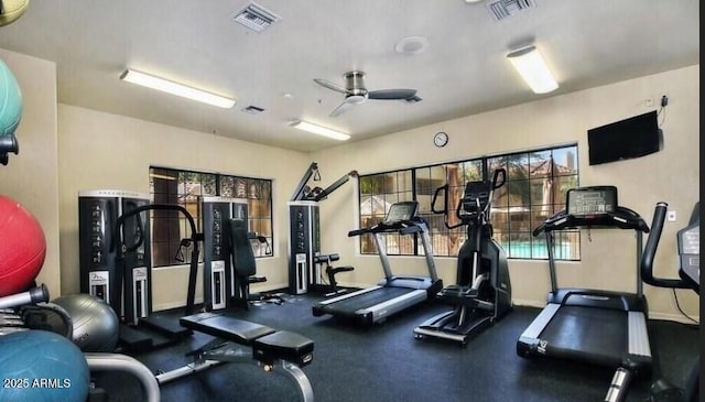 exercise room with baseboards, visible vents, and ceiling fan