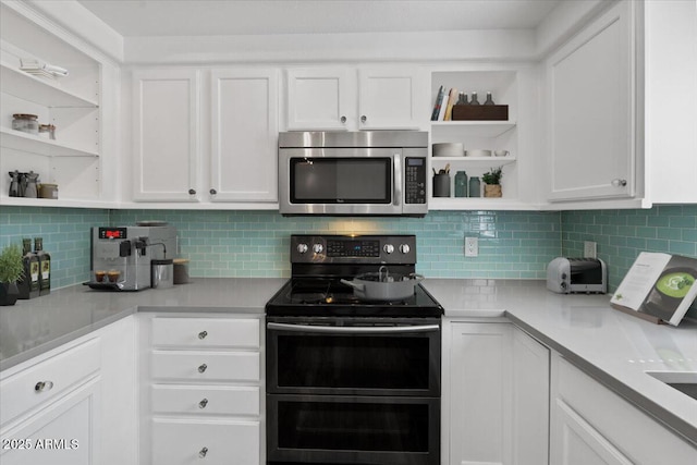 kitchen with open shelves, white cabinets, appliances with stainless steel finishes, and light countertops