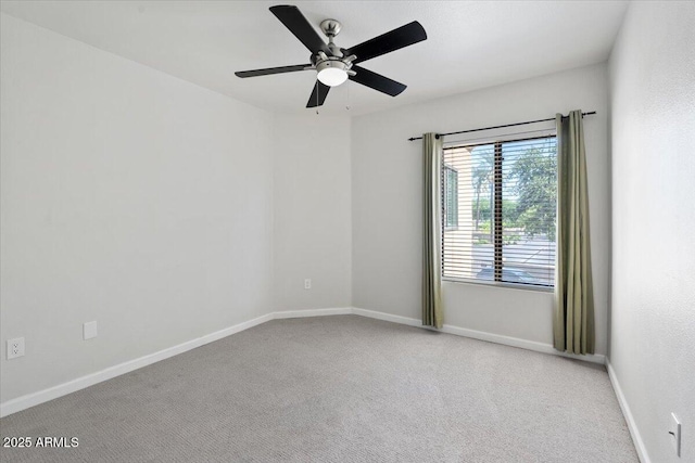 carpeted empty room with a ceiling fan and baseboards