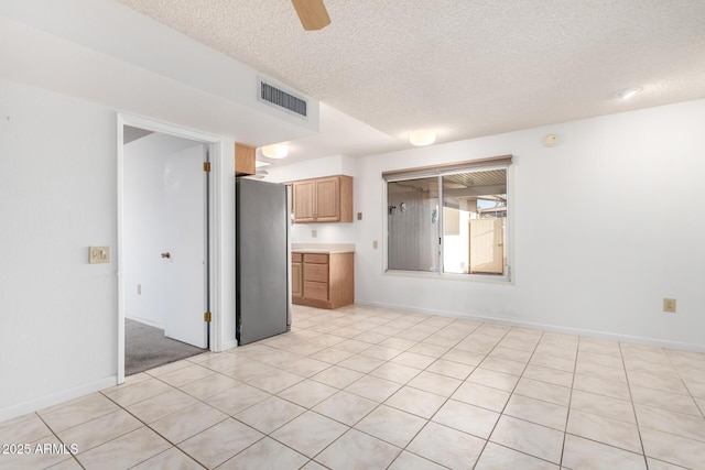 interior space featuring ceiling fan, stainless steel fridge, and a textured ceiling