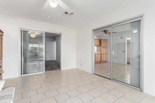 empty room with light tile patterned floors and ceiling fan