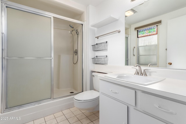 bathroom featuring vanity, toilet, a shower with shower door, and tile patterned flooring