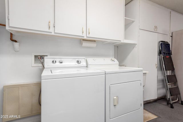 clothes washing area featuring cabinets and washer and dryer