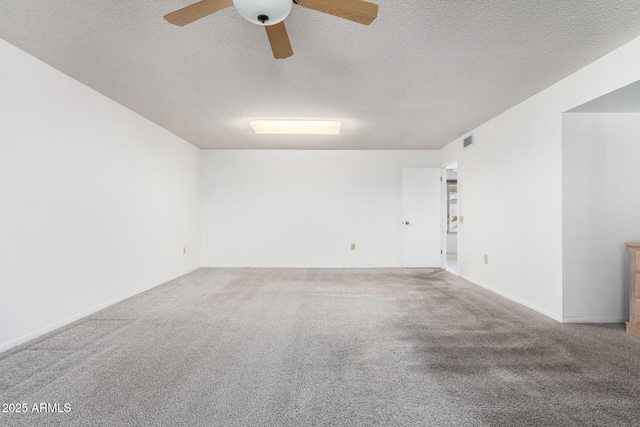 carpeted empty room featuring ceiling fan and a textured ceiling