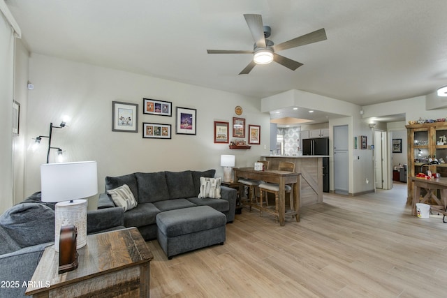 living room with ceiling fan and light hardwood / wood-style floors