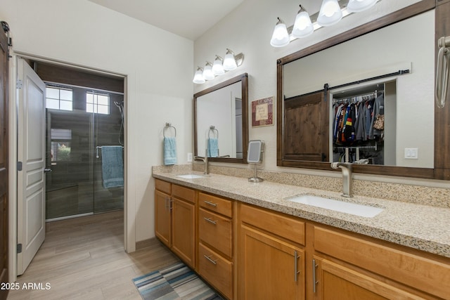 bathroom featuring hardwood / wood-style flooring, vanity, and an enclosed shower