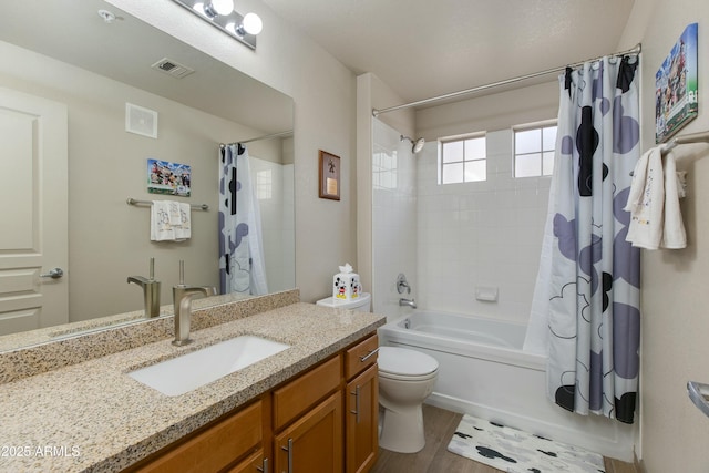 full bathroom with vanity, hardwood / wood-style floors, shower / bathtub combination with curtain, and toilet