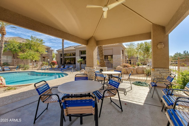 view of patio featuring a community pool and ceiling fan