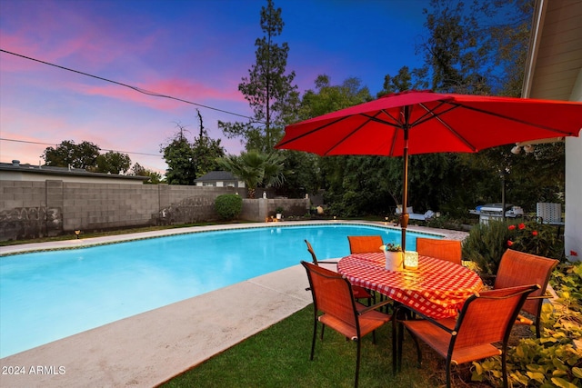 pool at dusk with area for grilling