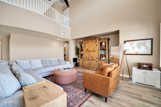 living room with a high ceiling and light hardwood / wood-style flooring