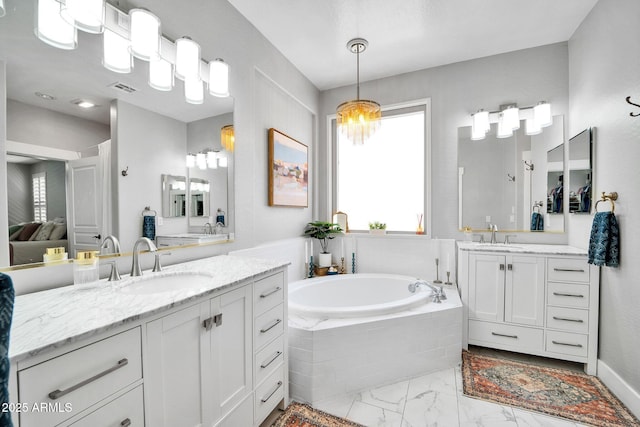 bathroom with vanity and tiled bath