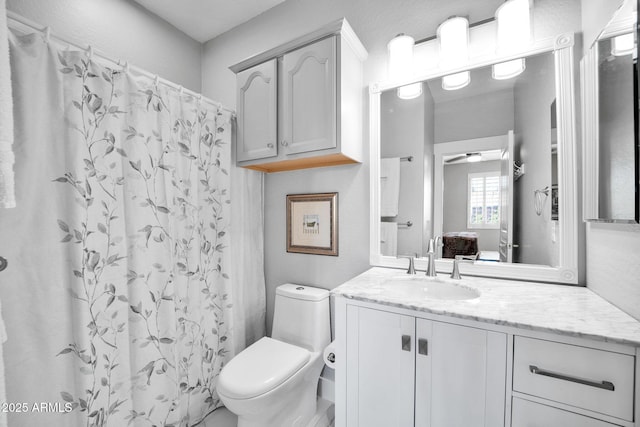 bathroom featuring a shower with curtain, vanity, and toilet