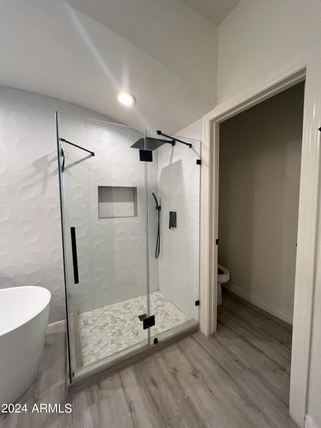 bathroom featuring hardwood / wood-style flooring, toilet, and separate shower and tub