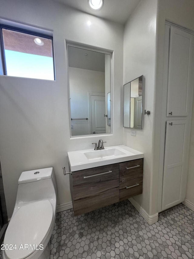 bathroom featuring vanity, tile patterned floors, and toilet