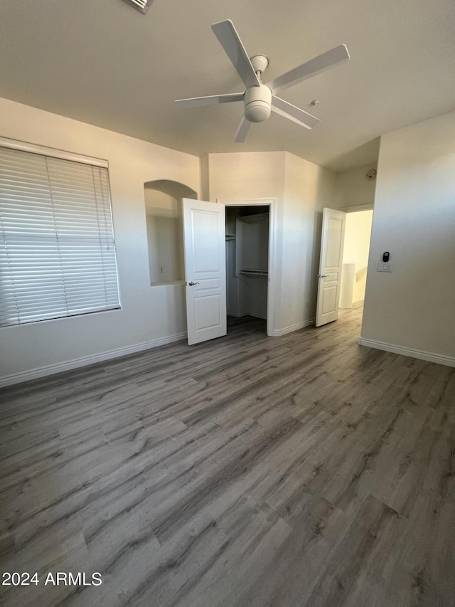 unfurnished bedroom with ceiling fan, hardwood / wood-style floors, and a closet