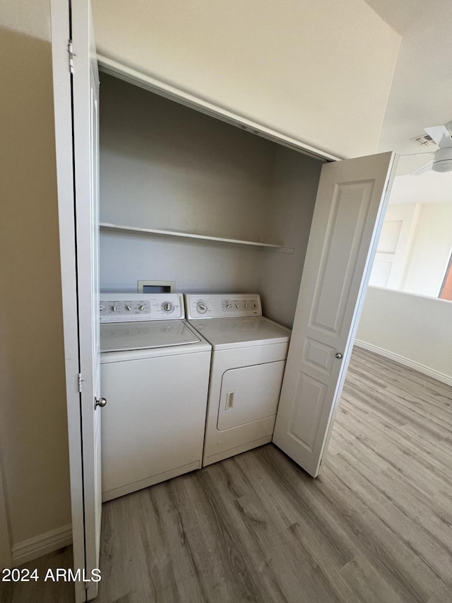 laundry room with washer and clothes dryer, light hardwood / wood-style flooring, and ceiling fan