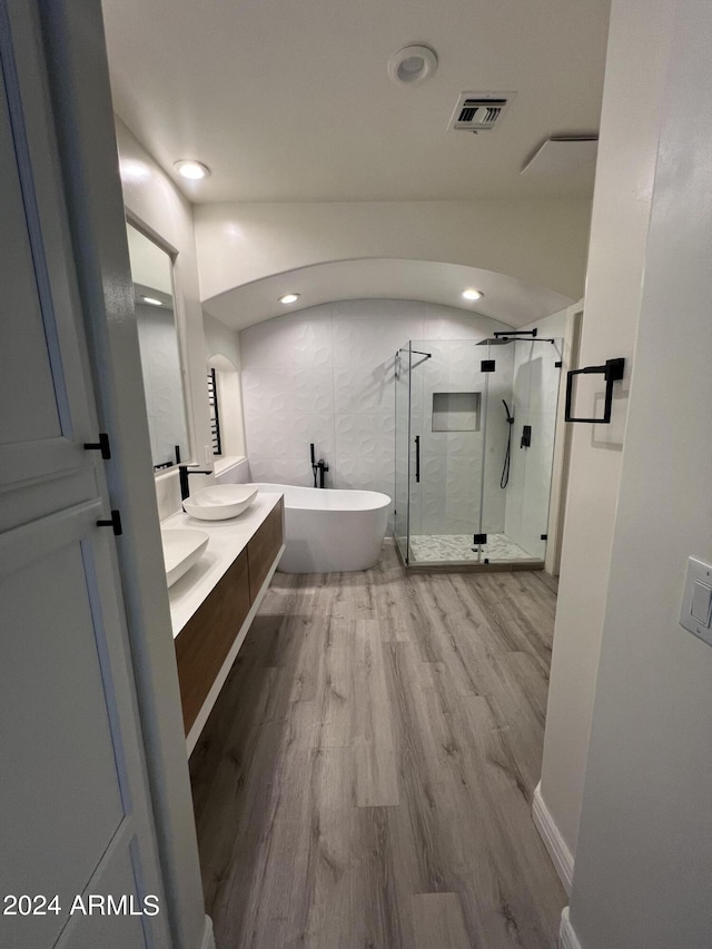 bathroom with vanity, independent shower and bath, and hardwood / wood-style floors