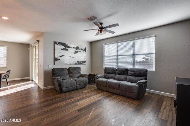 living room featuring ceiling fan and dark hardwood / wood-style floors