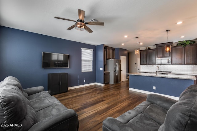 living room with ceiling fan, dark wood-type flooring, and sink